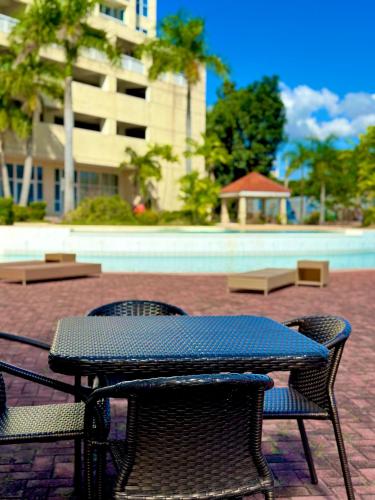 a picnic table and two chairs next to a building at La Mirada Deluxe Suites with Oceanview in Mactan