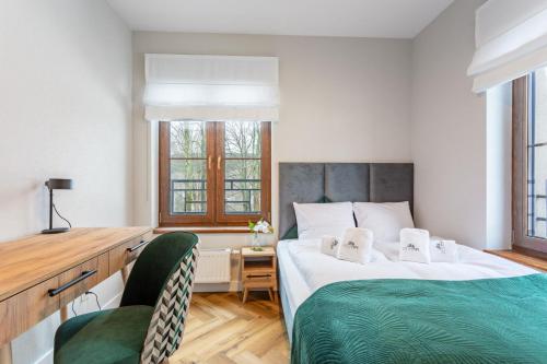 1 dormitorio con 1 cama grande y 2 sillas en Apart Invest Green Park Resort Apartament A14 Baseny, Sauny, Siłownia, en Szklarska Poręba