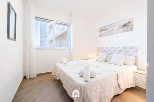 ein weißes Schlafzimmer mit einem großen Bett mit weißer Bettwäsche in der Unterkunft Mediterranean Way - Panoramic in Cambrils