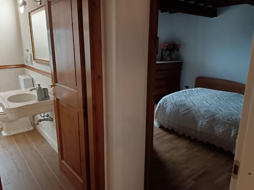 ein Bad mit einem Waschbecken, einem Bett und einem Spiegel in der Unterkunft Betta B&B in Gello
