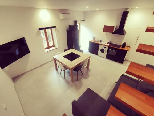 ein Wohnzimmer mit einem Tisch und einer Küche in der Unterkunft Le quai du Rhône in Sainte-Colombe