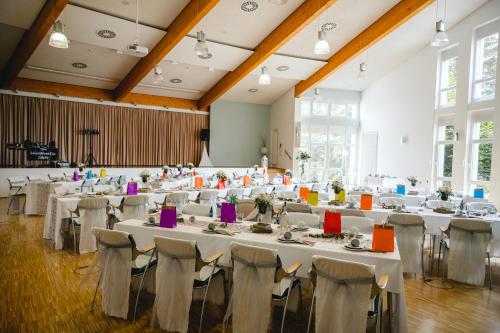 a large banquet hall with tables and chairs at Green Night Hotel in Falkenstein