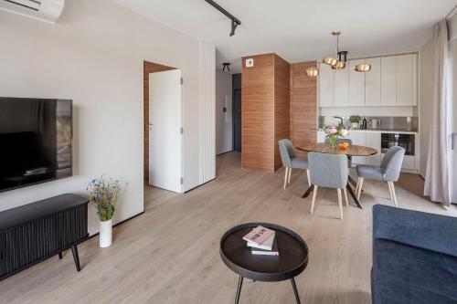 a living room with a couch and a table at Apartamenty na Półwyspie Wydma&Las in Jastarnia