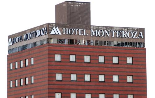 a building with a sign on the top of it at Hotel Monteroza Ohta in Ota