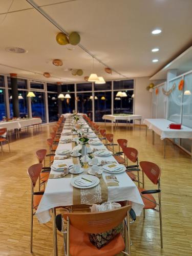 a long long table in a room with chairs and tables at Green Night Hotel in Falkenstein