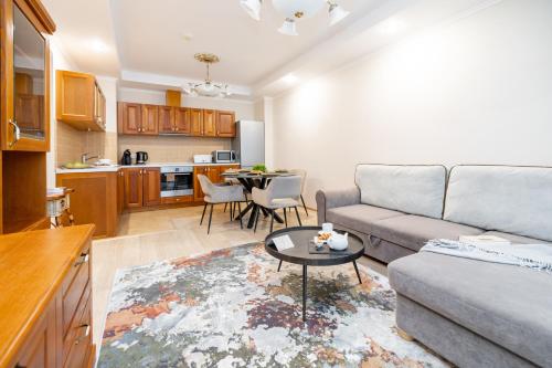 a living room with a couch and a table at Villa Alvīne Family Apart-Hotel in Jūrmala