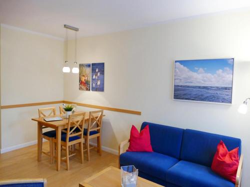 アールベックにあるFerienwohnung 3 03 Inselstrandのリビングルーム(青いソファ、テーブル付)