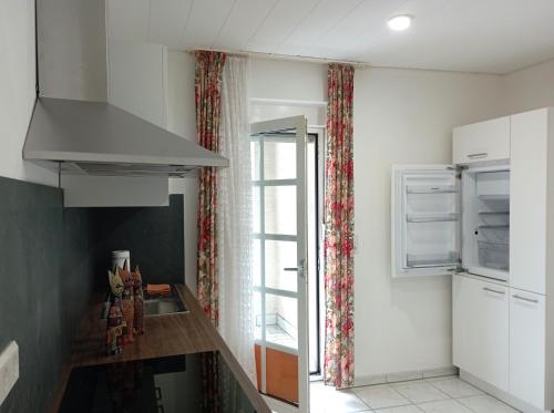 a kitchen with a sink and a refrigerator and a window at Monteurwohnung Renate in Saarbrücken