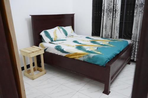 a bedroom with a bed with a wooden headboard and a bed sidx at 2 Bedroom spacious Cozy Home in Kigamboni,10 min Walk to Beach in Dar es Salaam