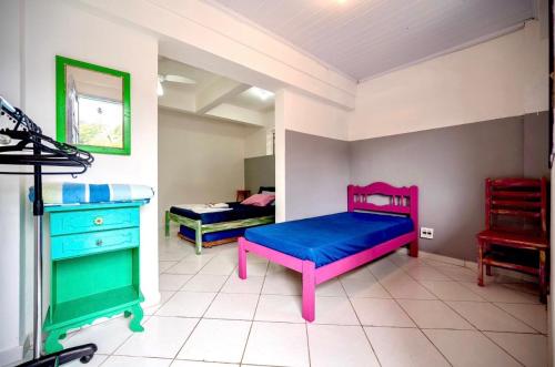 a room with two beds and a dresser in it at Pousada Água Marinha-Familias & Pets in Angra dos Reis
