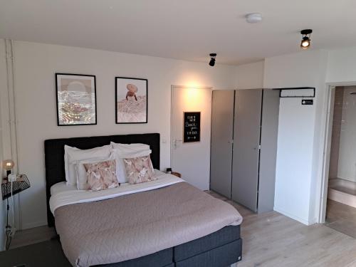 a bedroom with a large bed with pillows at Stad & Strand Studio in Middelburg