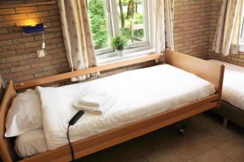 オッテルローにあるFamiliehuis De Sparの窓付きの部屋の木製ベッド1台