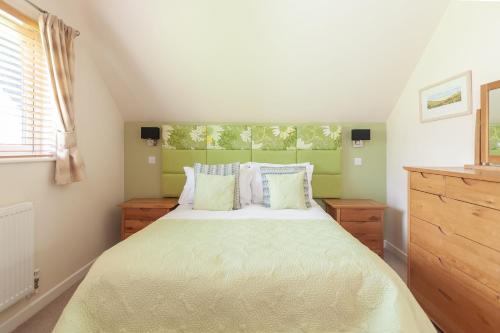 1 dormitorio con cama y ventana en KingFisher Hot Tub & log Burner house on Premium lakeside with Resort Facilities, en Saint Columb Major