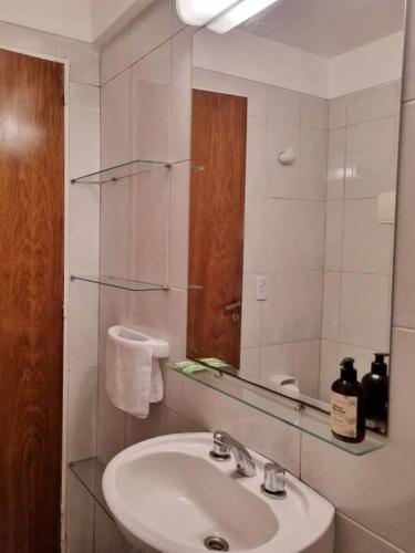 a bathroom with a sink and a mirror at Departamento en barrio Martin in Rosario