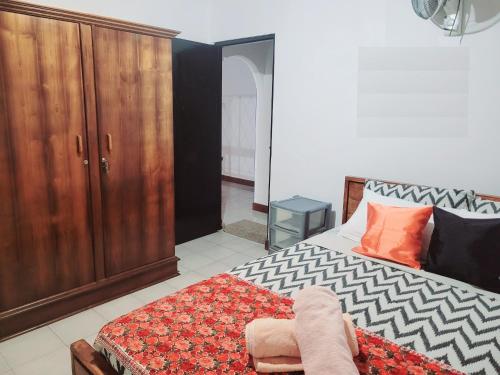a bedroom with a bed and a wooden cabinet at Traveller's casa closer to highway in Homagama