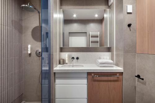 a bathroom with a sink and a shower at Apartamenty na Półwyspie Wydma&Las in Jastarnia
