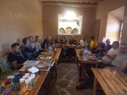 a group of people sitting at tables in a room at Casbah d'hôte La Jeanne Tourisme Ecologique in Boumalne