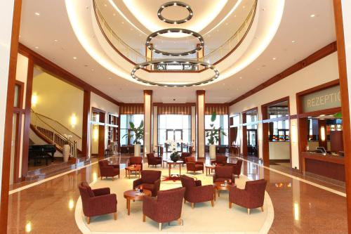 a hotel lobby with chairs and a chandelier at ATLANTIC Hotel Wilhelmshaven in Wilhelmshaven