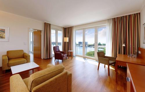 a living room with a couch and a table at ATLANTIC Hotel Wilhelmshaven in Wilhelmshaven