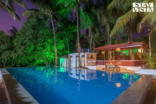 a villa with a swimming pool at night at StayVista's Firefly Mountain Retreat - Villa with Private Pool, Gazebo & Terrace in Karjat