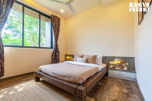 a bedroom with a bed and a large window at StayVista's Firefly Mountain Retreat - Villa with Private Pool, Gazebo & Terrace in Karjat