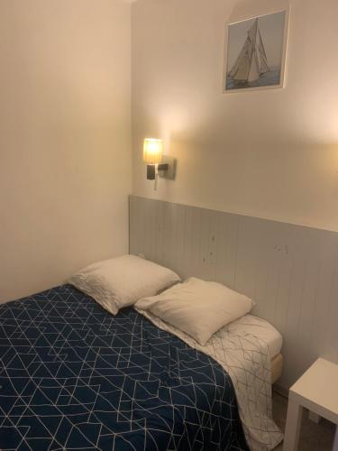 une chambre avec un lit avec deux oreillers dessus dans l'établissement Bord de mer et commerces 588, à Cannes