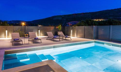 a swimming pool with two chairs and avisor at Villa Nono in Dubrovnik
