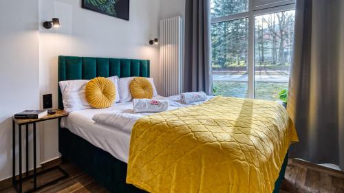 a bedroom with a large bed with a yellow blanket at Apartament Luxury 3 sypialnie, Sauna i Klimatyzacja - 5D Apartamenty in Świeradów-Zdrój