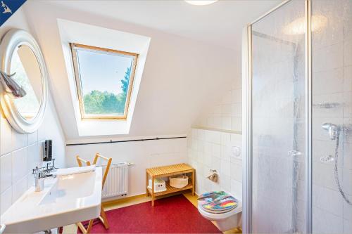 a bathroom with a sink toilet and a window at Ferienhaus Wilde Wiese in Sellin