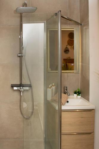 une douche avec une porte vitrée à côté d'un lavabo dans l'établissement Le Vieux-port Cosy bohème, à Marseille