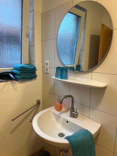 ein Bad mit einem Waschbecken und einem Spiegel in der Unterkunft Haus Monika in Juist