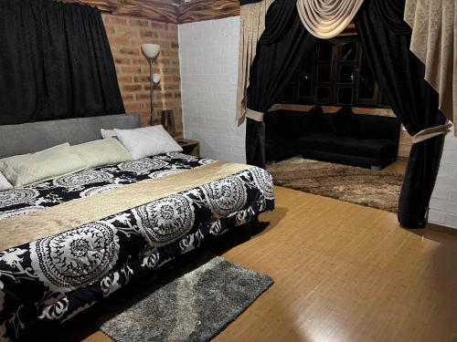 a bedroom with a bed and a couch at Finca Hotel Paraiso Urrao in Urrao