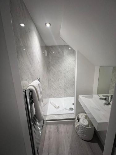 a bathroom with a shower and a tub and a sink at The Harbour Cottage in Peterhead