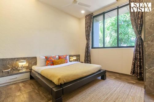 a bedroom with a bed and a large window at StayVista's Firefly Mountain Retreat - Villa with Private Pool, Gazebo & Terrace in Karjat