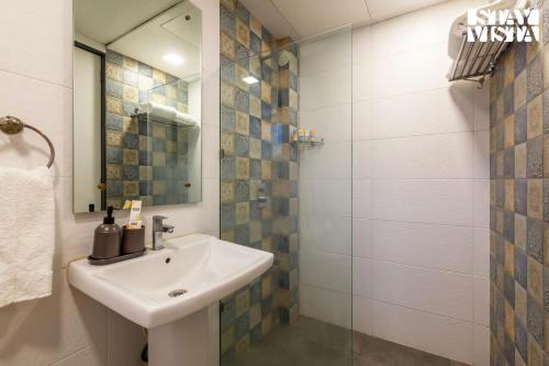 a bathroom with a sink and a glass shower at StayVista's Firefly Mountain Retreat - Villa with Private Pool, Gazebo & Terrace in Karjat