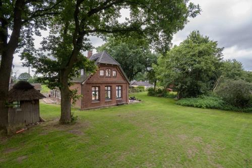 een groot huis in een tuin met een boom bij Denkmalgeschützte Alte Schule nahe Hamburg in Buxtehude