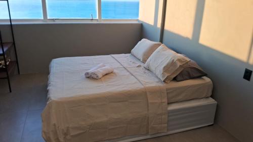 a bed with a towel on it in a room at Sol Victoria Marina Flat in Salvador