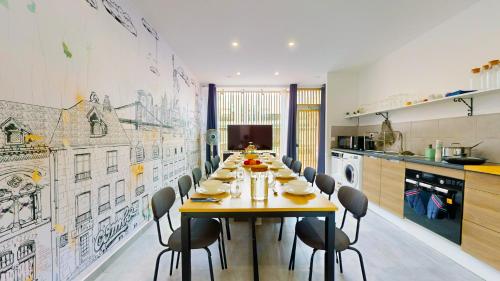 une salle à manger avec une longue table et des chaises dans l'établissement Grande amiénoise hyper-centre, 2 Parkings, Terrasse, Vue, BBQ, Hamac, Salle de Jeux, à Amiens