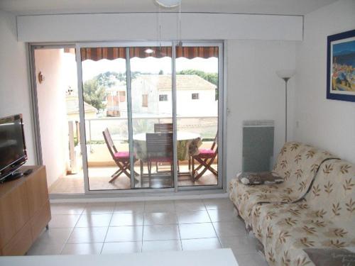 - un salon avec un canapé et une vue sur une terrasse dans l'établissement Beau 2 pièces proche plage et vue mer, à Cavalaire-sur-Mer