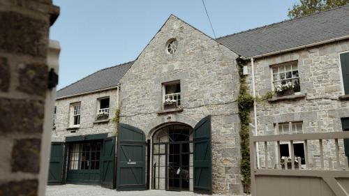 an old stone building with green doors and windows at Gileston Manor Estate in Barry