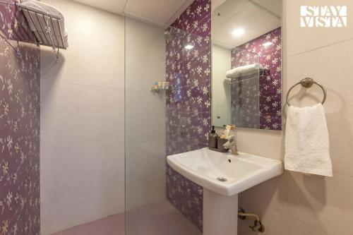 a bathroom with a sink and a glass shower at StayVista's Firefly Mountain Retreat - Villa with Private Pool, Gazebo & Terrace in Karjat