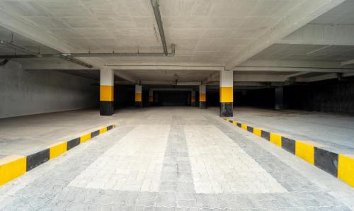 an empty parking garage with yellow and black stripes at Treebo Skydale Premium Suites, 1500 Mtrs From Ooty Lake in Ooty