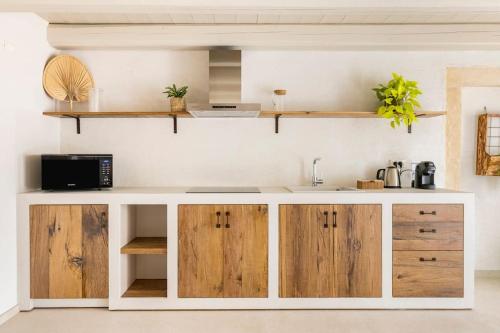 a kitchen with wooden cabinets and a sink at VerdeOlivo 1876 - Apartments & Pool in Mezzane di Sotto