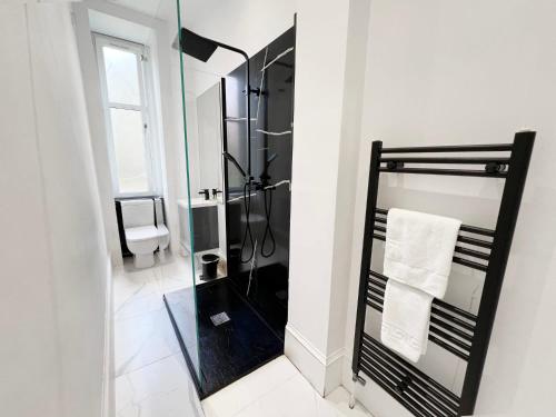 een badkamer met een douche en een spiegel bij Cosy Glasgow Retreat with Modern Amenities in Glasgow
