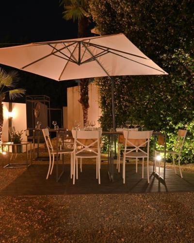 a table and chairs under an umbrella at night at Ghe kalè Resort in San Paolo Bel Sito