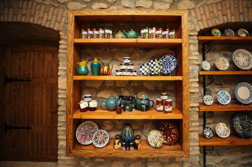 a shelf full of plates and bowls on a wall at Art Hotel by ABAD Guest in Sheki