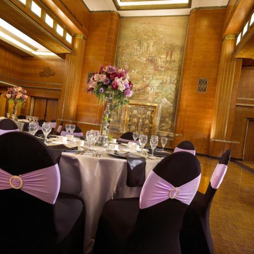 a dining room with a table with chairs and a vase of flowers at The Queen Mary in Long Beach