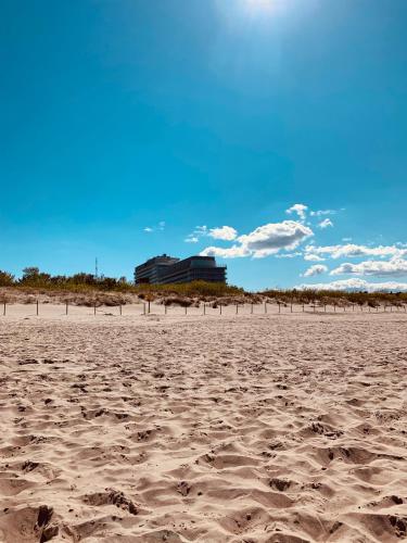 a sandy beach with a building in the background at Zdrojowa Sun Apartment in Świnoujście