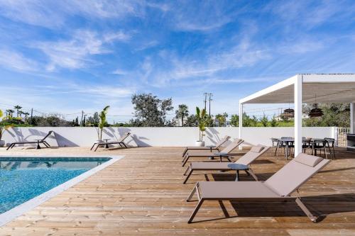 a deck with lounge chairs and a swimming pool at Casa Felicidade in Carvoeiro