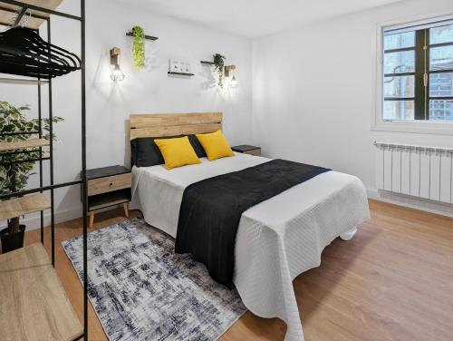 Un dormitorio con una cama con almohadas amarillas. en Pedra Nova - Céntrico, Lujoso en Pontevedra